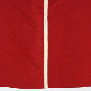 Vue macro détaillée du tissu rouge avec une bordure en dentelle tissée dorée