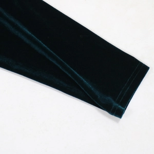 Detailed close-up of dark green velvet sleeve cuffs with smooth double-needle stitching