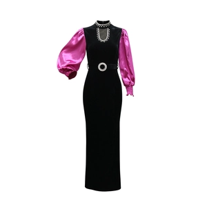 Detail of black velvet slim gown with rose satin puff sleeves and rhinestone belt buckle