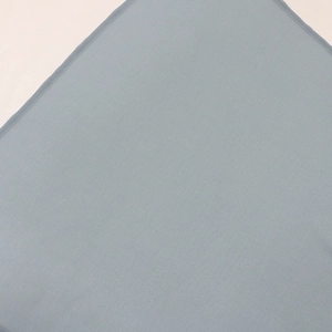 Close-up of grey blue sequin dress fabric showing plain weave texture and stitching