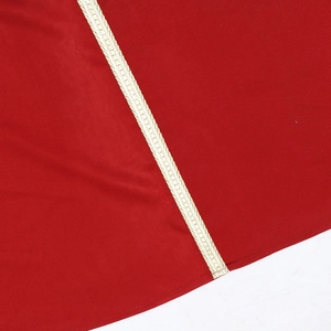 Vue détaillée du tissu rouge avec bordure tissée dorée métallique et textures de robe