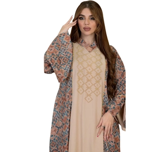 Close-up of golden diamond geometric embroidery and vibrant ethnic print on abaya robe