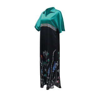 Detailed view of green satin bodice and ethnic floral print on long maxi dress