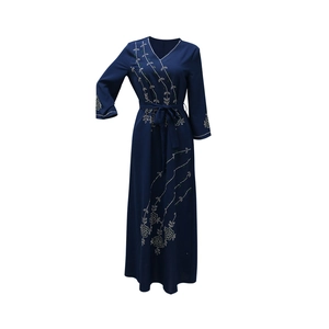 Close-up of silver rhinestones and flower embroidery on dark blue long-sleeved dress