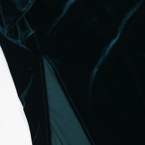 Macro shot of dark green velvet fabric texture and clean stitching of side slit detail