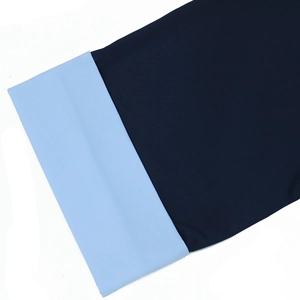 Détail des poignets en patchwork bleu marine et bleu clair avec des coutures de qualité