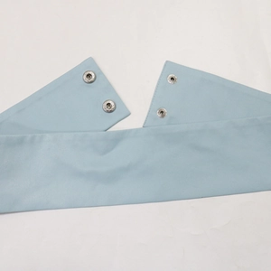 Detailed close-up of light blue fabric texture with silver snap buttons and neat stitching