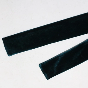 Detailed view of dark green velvet ribbon fabric with smooth texture and soft sheen