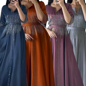 Détail de robes à manches longues en satin avec strass étincelants en plusieurs couleurs