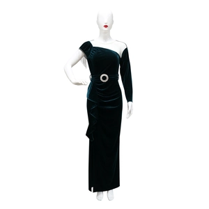 Close-up of dark green velvet dress featuring an asymmetrical shoulder with chain tassels