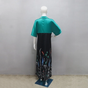 Detail of emerald green satin top and floral print skirt on contrast maxi dress