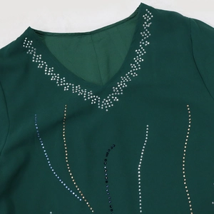 Close-up of neckline detail on chiffon robe with colorful rhinestones and beading