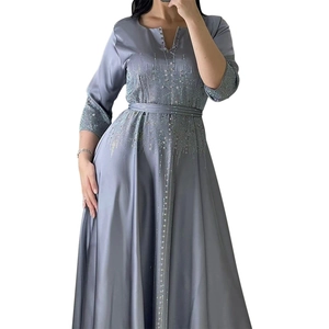 Détails de broderies pailletées argentées et de strass sur robe de soirée en satin