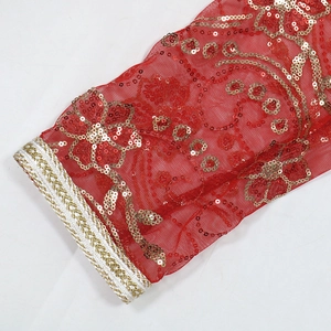 Détail de robe en tulle rouge avec broderies à paillettes dorées et galon tissé doré