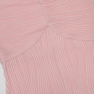 Dettaglio ravvicinato del tessuto a pieghe rosa chiaro con texture e cuciture rifinite