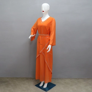 Detail of orange chiffon robe dress with silver rhinestone leaf patterns and waist belt