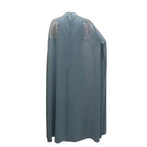 Detail of silver sequins and long fringe on the shoulder of this dark cyan cape gown