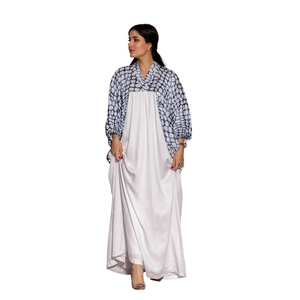 Detail der Fledermausärmel mit blauem Geometrie-Print an einer weißen Kontrast-Abaya-Robe