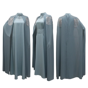 Detailed view of silver tassels and rhinestone embellishments on a light blue-grey kaftan cape