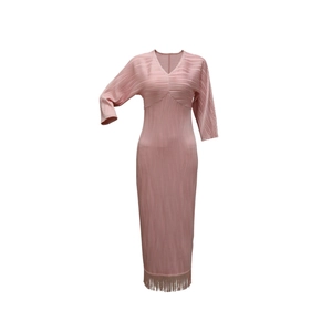 Dettaglio del vestito rosa a pieghe con scollo a V e frange eleganti sul fondo