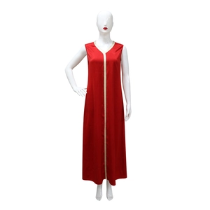 Détail d'une robe longue en satin rouge avec ruban brodé doré et décolleté en V