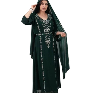 Detailed close-up of intricate white embroidery on the dark green robe sleeve and collar