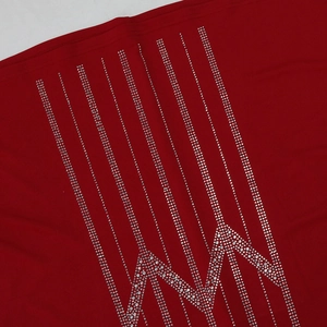 Close-up of red chiffon robe featuring vertical rhinestone stripes and geometric patterns