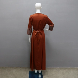 Détail d'une robe de soirée en satin avec poignets en strass et nœud à la taille