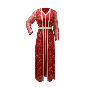 Détail de la robe caftan rouge avec broderies florales dorées et ornements en paillettes