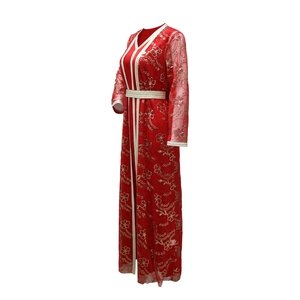 Détail de la broderie florale dorée sur caftan en maille rouge avec rubans décoratifs