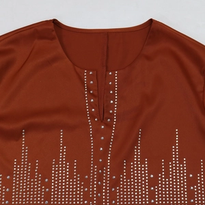 Détails de la robe en satin caramel avec lignes verticales de strass étincelants