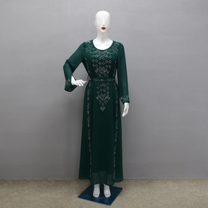 Detailed view of dark green dress with silver rhinestone geometric patterns and cinched waist