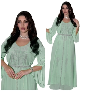 Close-up of mint green chiffon dress featuring silver rhinestone patterns and flared sleeves