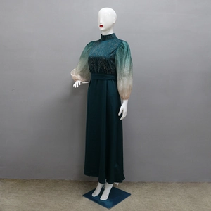 Detail of green jalabiya dress featuring rhinestone patterns and gradient puff sleeves