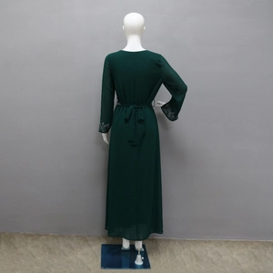 Detailed back view of a dark green maxi dress with waist tie and beaded cuffs