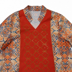 Detail of red bodice with golden rhinestones and geometric ethnic print patterns