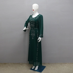 Detail of emerald green maxi dress showing intricate silver rhinestone patterns and fabric