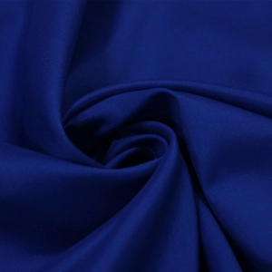 Vista macro del tessuto blu scuro per abito da sera con consistenza setosa e pieghe a spirale