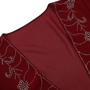 Dettaglio dell'abito in chiffon bordeaux con ricamo floreale di strass argentati