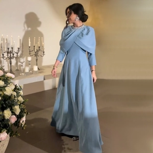 Détail de l'encolure en strass et du drapé croisé sur une robe longue bleu clair