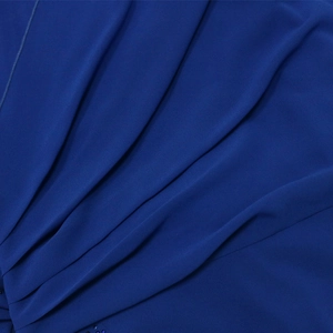 Dettaglio del tessuto dell'abito in chiffon blu reale con strass e trama a pieghe