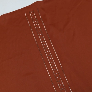 Détail macro de rayures verticales en strass sur tissu de robe de soirée en satin rouge brique