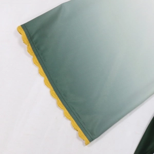 Close-up of a green gradient fabric dress featuring yellow wavy stitched lettuce edges
