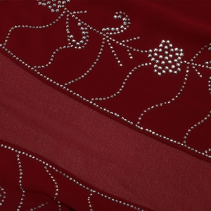 Dettaglio del tessuto in chiffon rosso con intricati motivi floreali e di strass argento