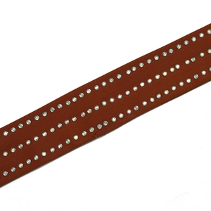 Détail de bretelle de robe en satin marron avec trois rangées de strass AB