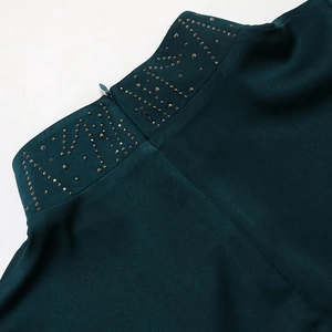 Detail of emerald green jalabiya high neck with silver rhinestones and back zipper