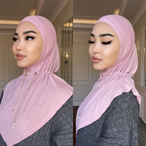 Dettaglio foulard hijab rosa, elegante catena di perle, tessuto morbido e copricapo.
