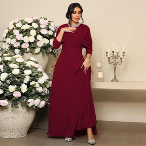 Détail d'une robe de soirée bordeaux avec décolleté croisé et perles élégantes brodées