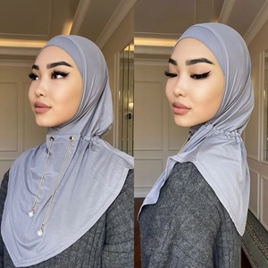 Hijab musulmano grigio con catena dorata e ciondoli di perle, vista dettagliata della modella.