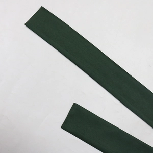 Detailed close-up of dark green rhinestone robe fabric with fine stitching and smooth texture